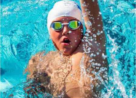 BSwim - Back Stroke Classes. Boy swimming backwards in pool.